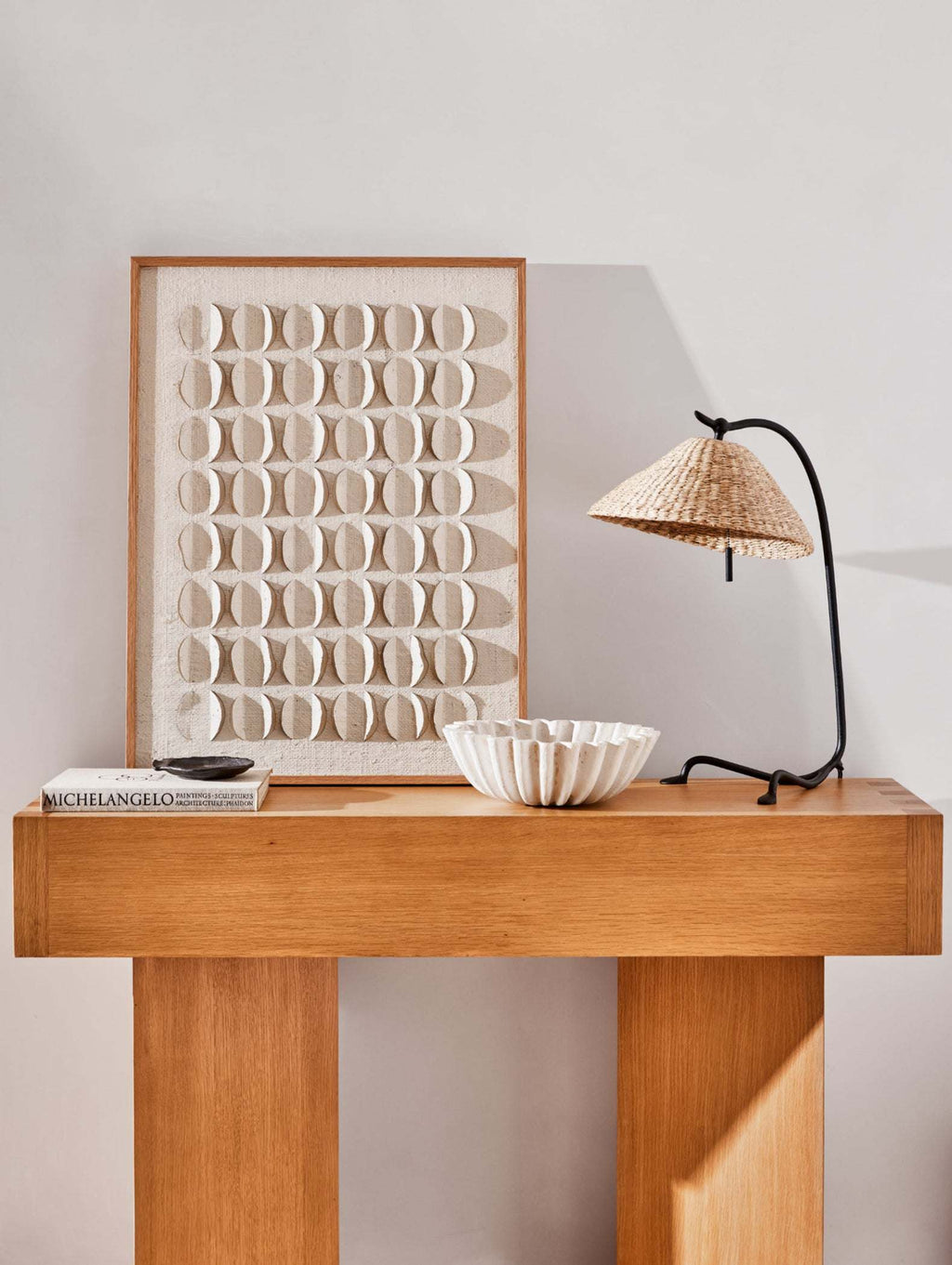 Wooden console table with decorative items and a Bainbridge table lamp against a light wall