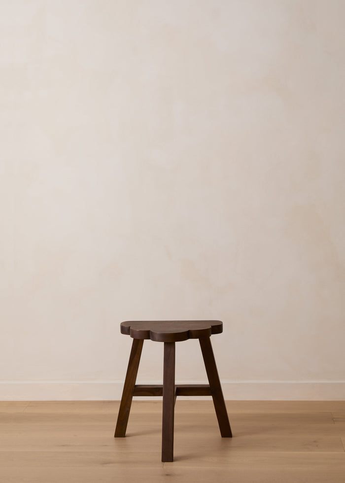 Wooden cloud shaped accent stool against a plain wall