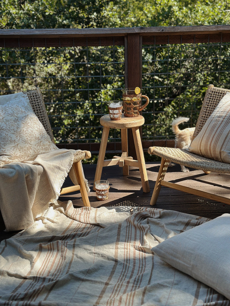 Outdoor seating area with our Marin Lounge chairs, a small table, and cushions on a deck. Saffron + Poe