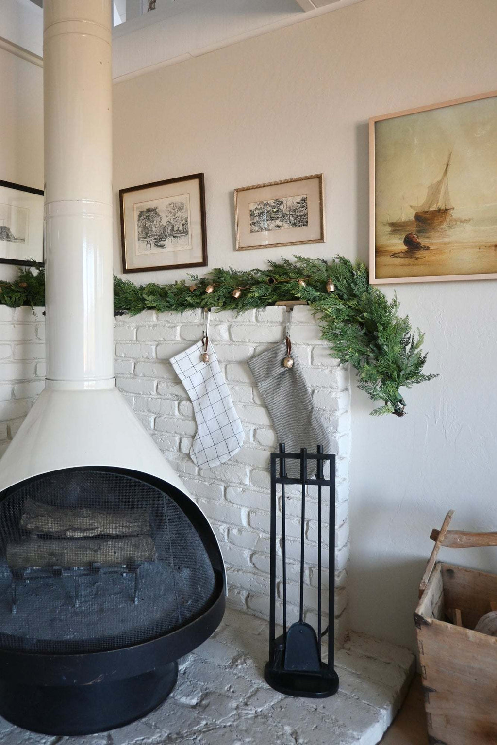 Handmade Natural Linen Stocking with subtle pinstripe, antique bell, and cinnamon ribbon hanging on a fireplace mantel