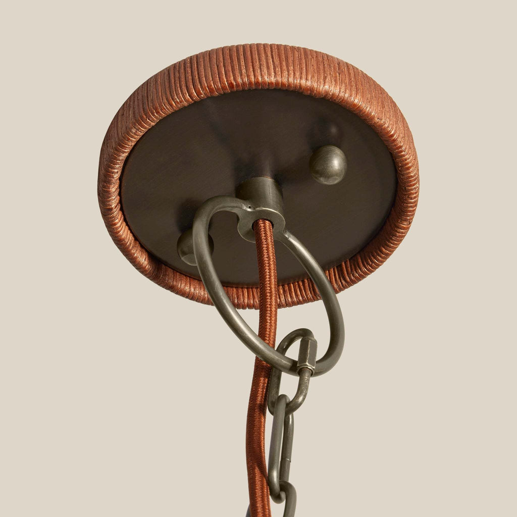 Close-up of Delphine Chandelier ceiling canopy with pewter finish on a beige background.