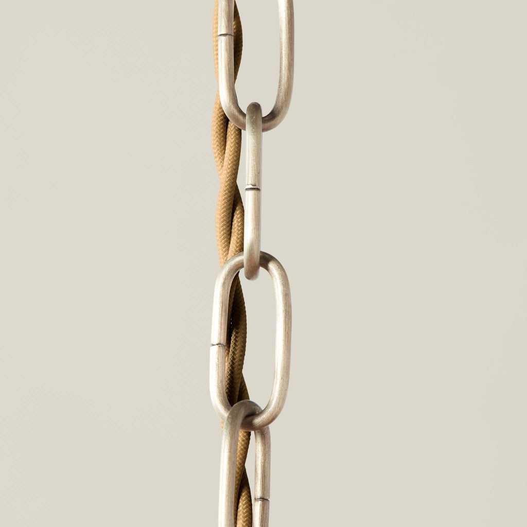 Close-up of a metal chain of Delphine chandelier with a beige background