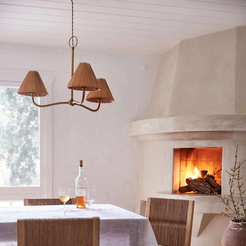 Dining room with a fireplace, Delphine chandelier, and table setting.