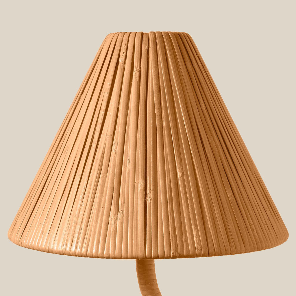 A close-up of a pleated woven lampshade of the Delphine Chandelier in a warm tan or light brown tone, shown against a plain light beige background.