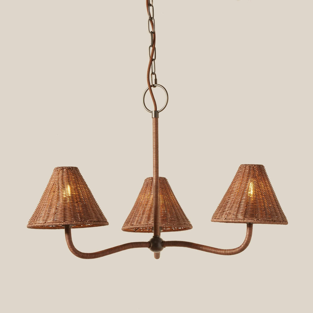Delphine three-light wicker pendant chandelier with a pewter metal frame and textured woven shades, suspended from a chain against a solid beige background.