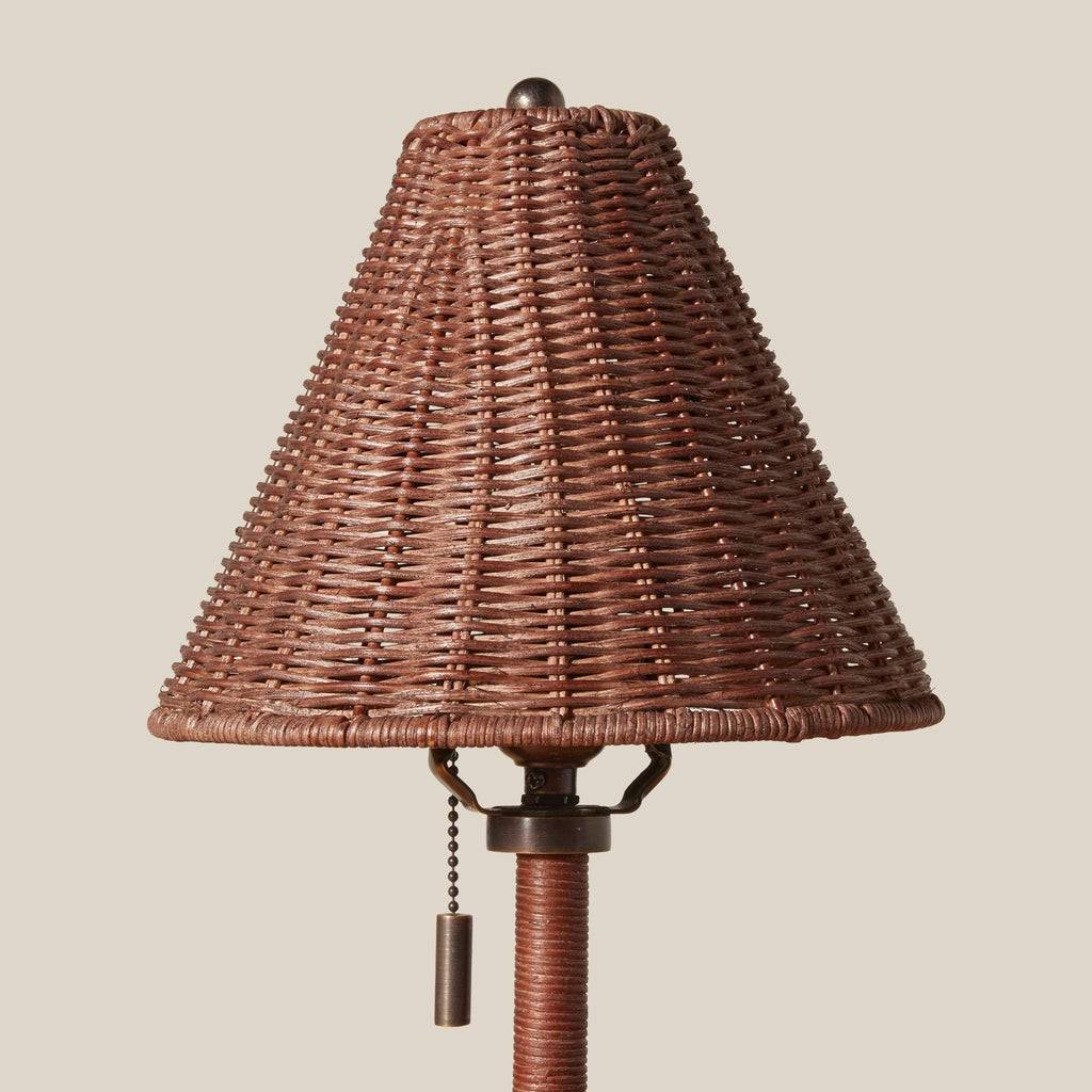 Wicker lampshade of a Delphine table lamp with pull chain on a beige background
