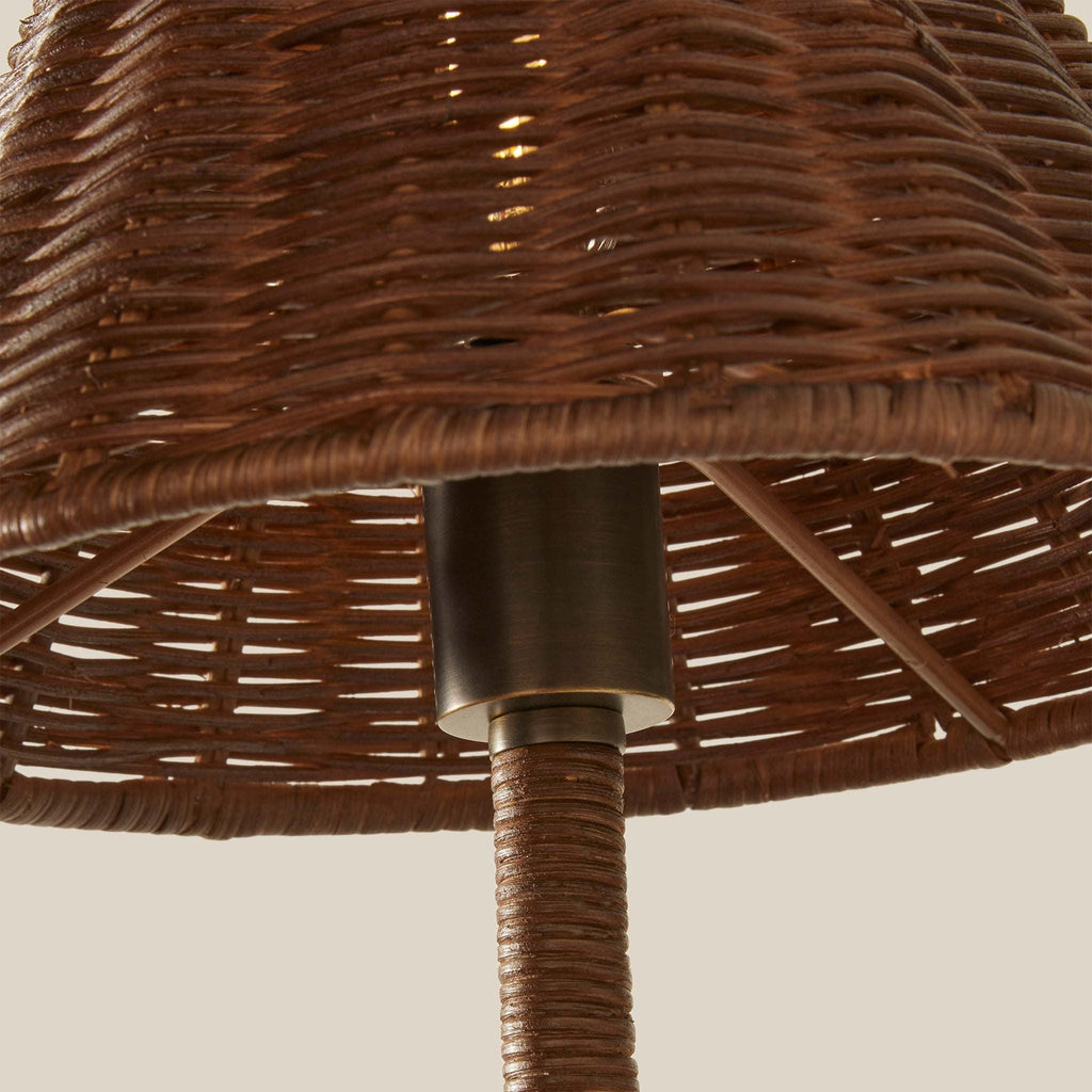 Close-up of woven wicker delphine lampshade and matching wrapped stem, showing a dark metal socket collar against a plain light beige background.
