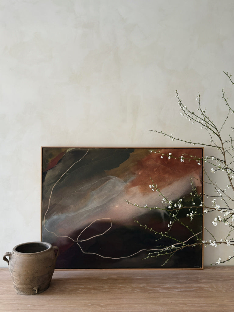 Ember Sky One-of-a-Kind Painting by Jaime Lovejoy with antique vessel and cherry blossoms on oak dining table against lime washed wall. Saffron + Poe