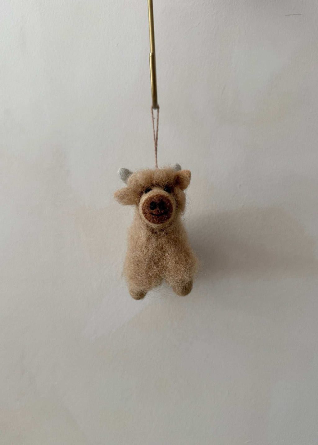 Handcrafted felt Highland cow ornament made from natural wool with rustic Scottish charm