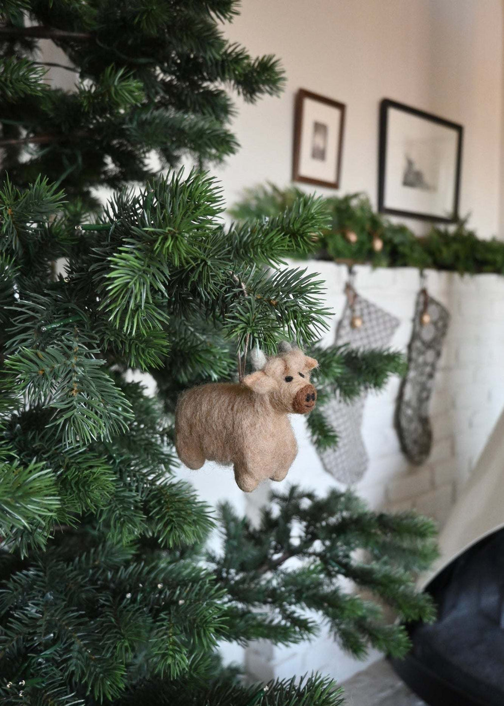 Handcrafted felt Highland cow ornament made from natural wool, showcasing rustic charm and shaggy detail.