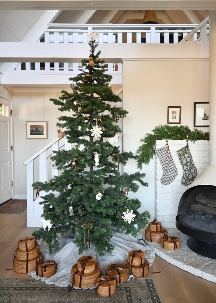 Decorated Christmas tree with handmade ornaments, baskets and stockings in a home setting. Saffron + Poe