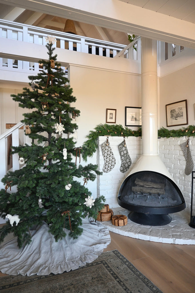 Living room with Christmas tree and decorated fireplace.
