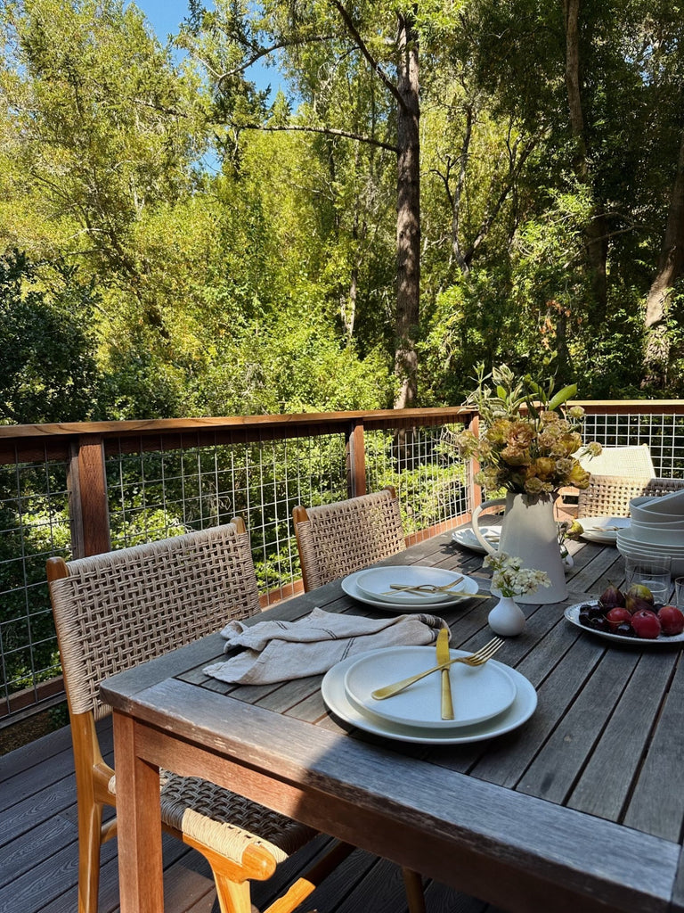 Woven Faux Rattan Marin Dining Chair styled on an outdoor deck. -Saffron and Poe