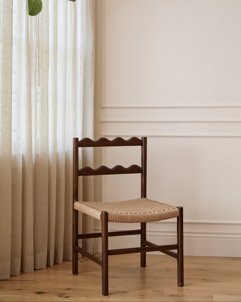 Ionian scalloped dining chair with woven seat in dining room with white oak flooring and paneled walls. Saffron and Poe