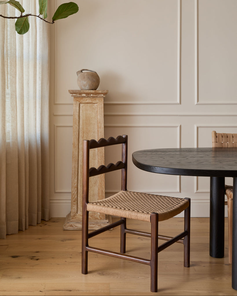 Ionian scalloped dining chair with woven seat in dining room with white oak flooring and paneled walls. Saffron and Poe