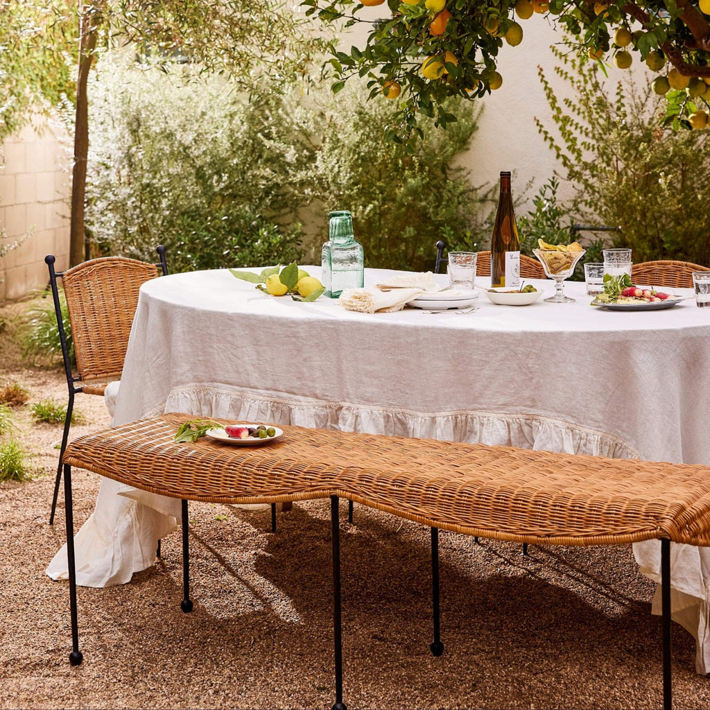 Outdoor dining setup with Lacoste indoor-outdoor dining chairs and Lacoste Bench under a lemon tree.