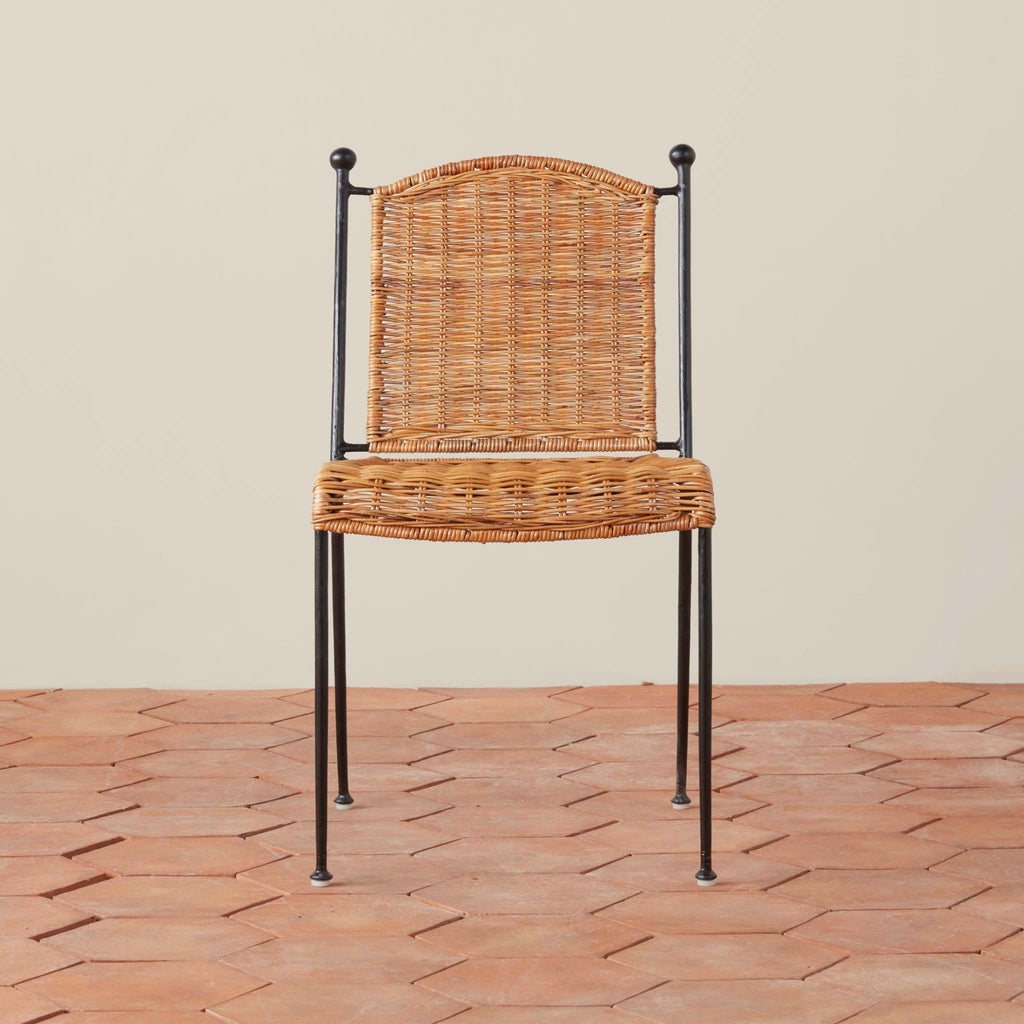 Rattan Lacoste Indoor-Outdoor Dining Chair with metal frame on a terracotta tile floor.