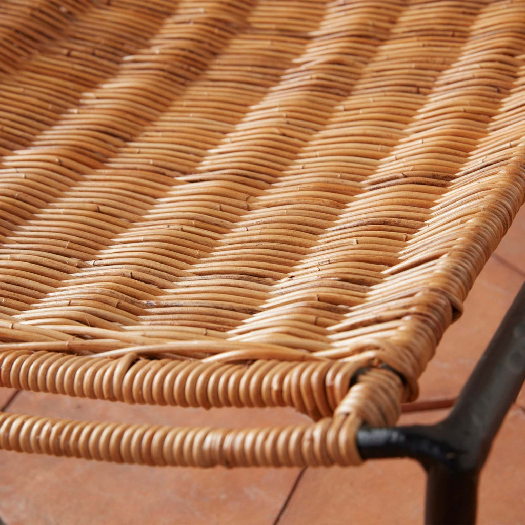 Close-up of rattan Lacoste Indoor-Outdoor Lounge chair with tile floor background.
