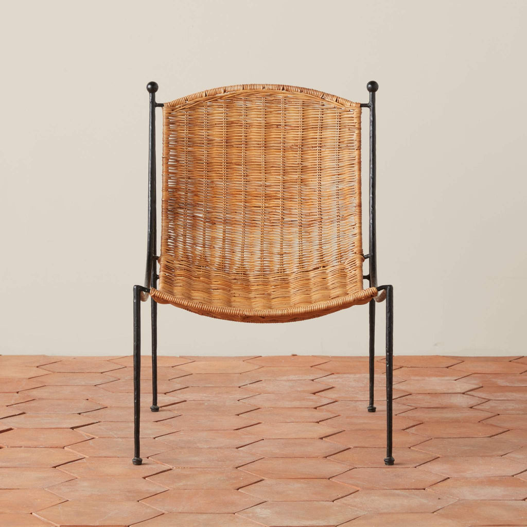 Front view of wicker Lacoste Indoor-Outdoor Lounge Chair with black metal iron frame on a tile floor.