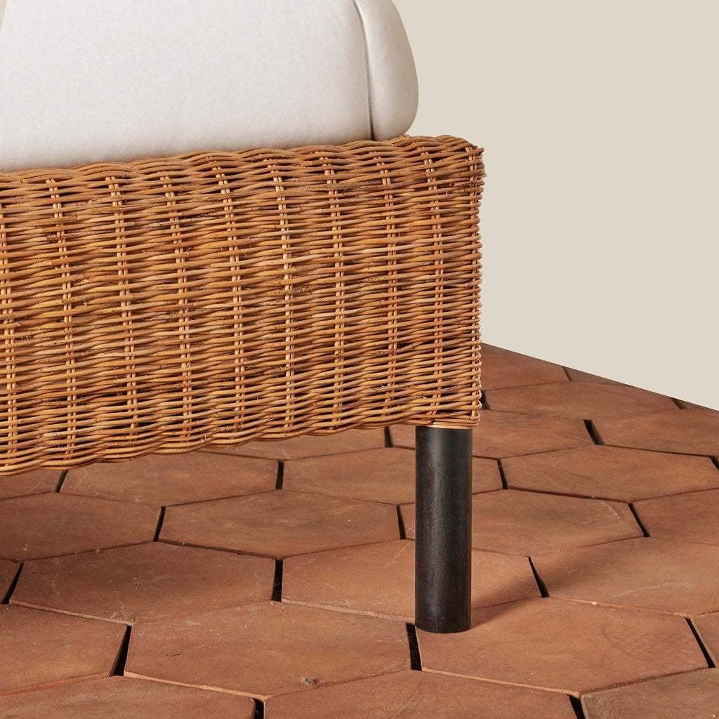 Lacoste Queen Bedframe detail of woven rattan and iron leg.