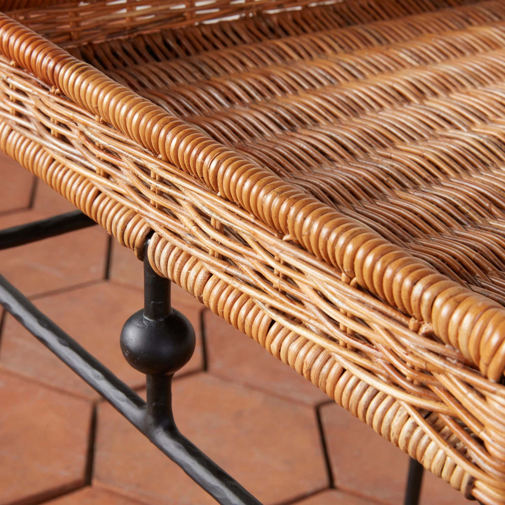 Close-up of rattan Lacoste side table with a metal frame on a terracotta floor.