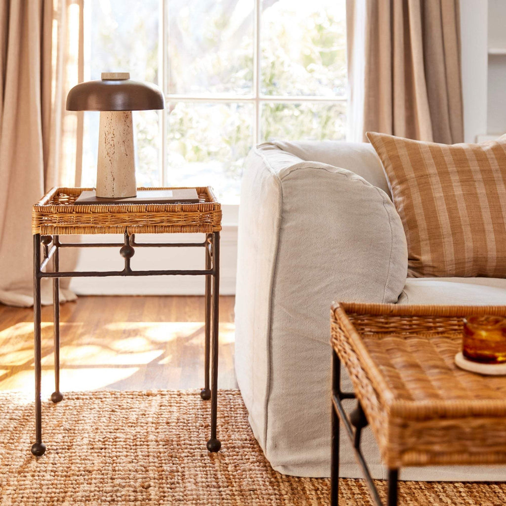 Lacoste Side Table in a living room next to a beige sofa and lamp.