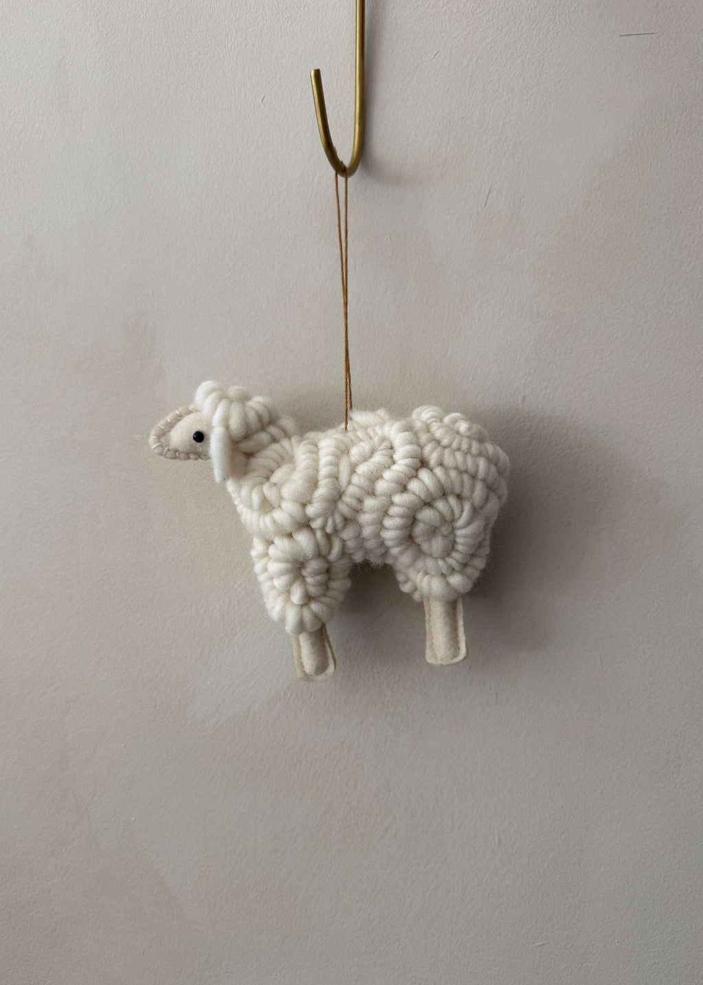 Handmade wooly sheep ornament with off-white cotton knit body and cream felt face for holiday decor