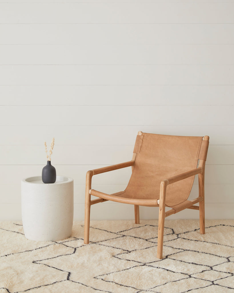 Leather Sling Lounge chair on a Beni Orin Moroccan rug with a white wall background
