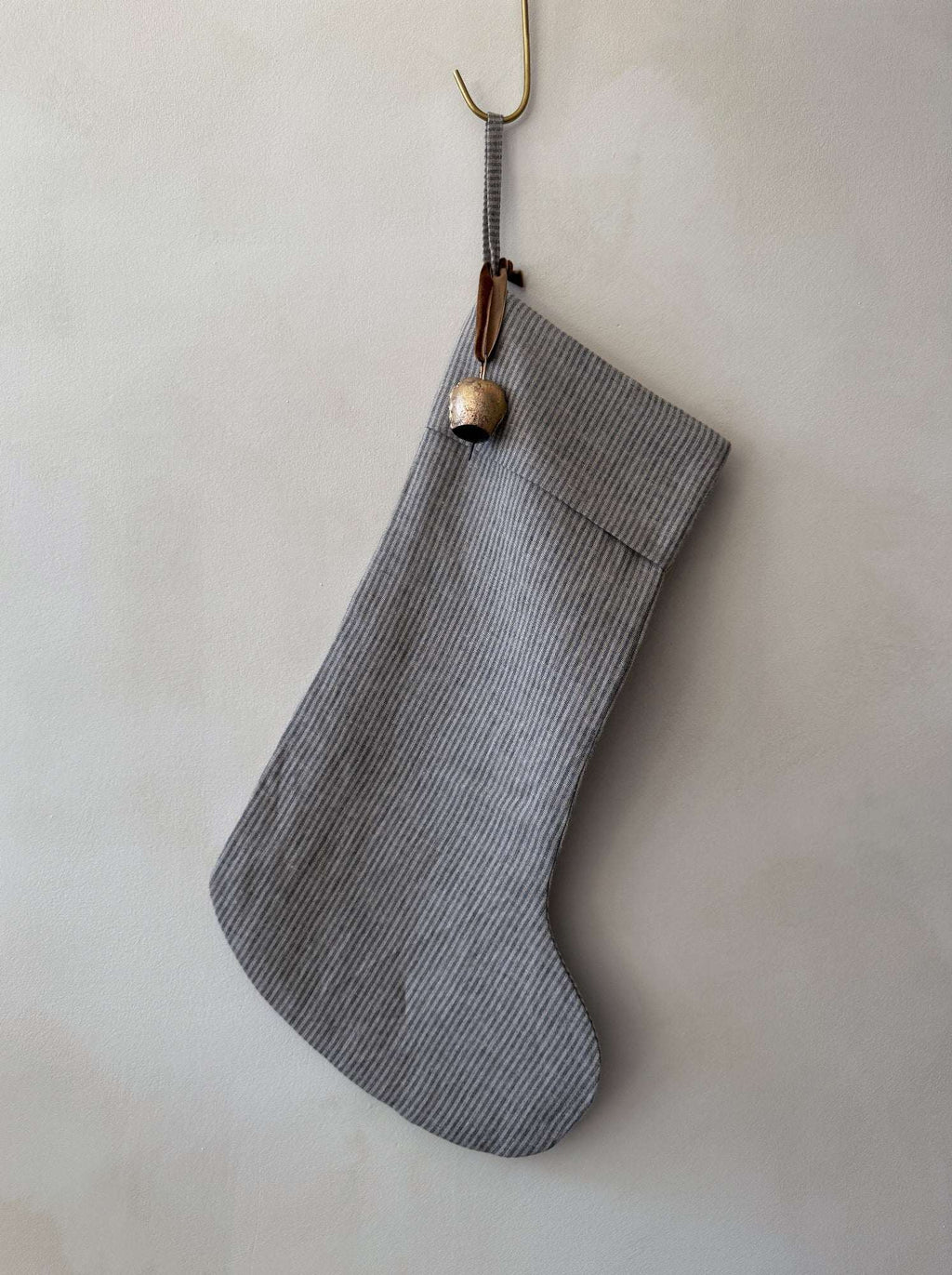 Natural linen stocking with pinstripe pattern, antique brass bell, and cinnamon ribbon, handmade and double lined for holiday decor