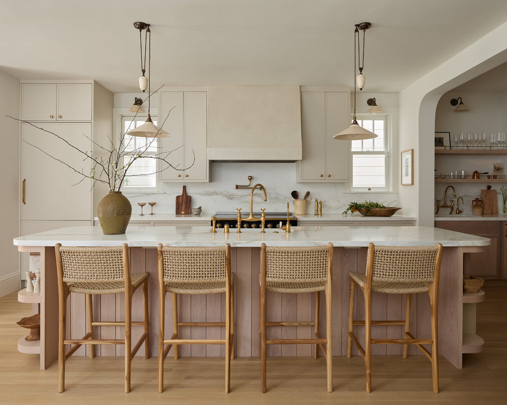 Marin Faux Rattan Counter Stool in modern timeless kitchen with white oak and cream cabinets, wide angle view.