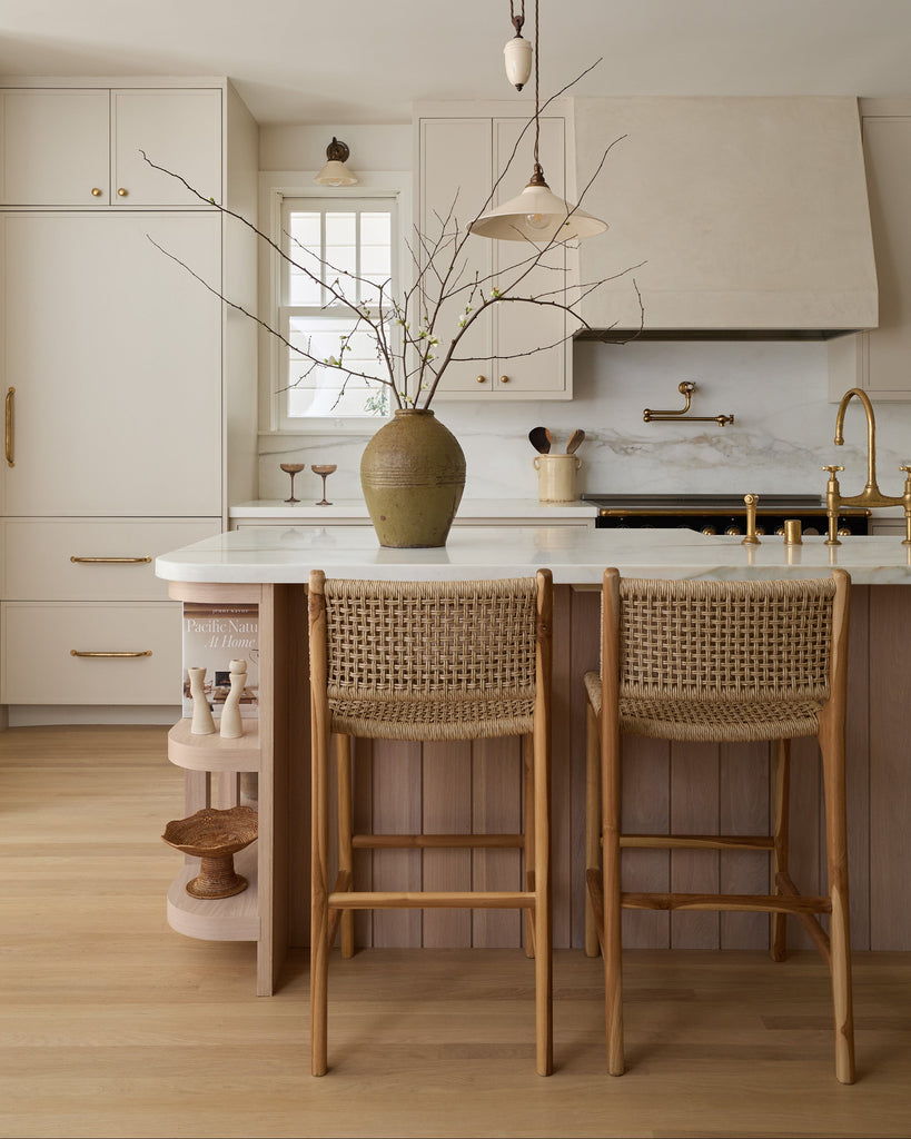 Marin Faux Rattan Counter Stool styled in a modern timeless kitchen with white oak and cream cabinets.