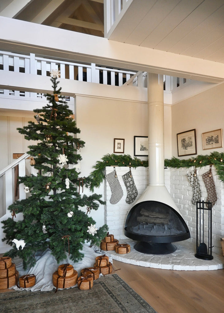 Cozy living room with Christmas tree, stockings, and fireplace.