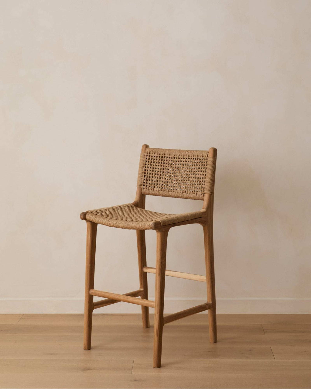 Woven paper cord counter stool against a limewash wall