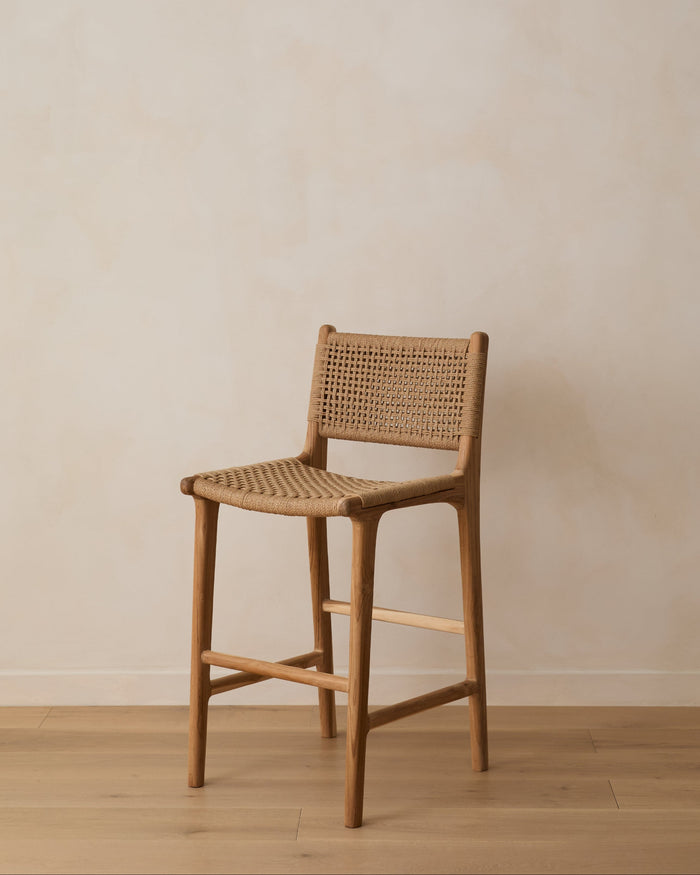 Woven paper cord counter stool against a limewash wall