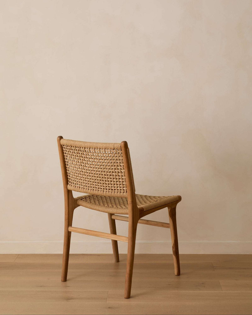 Paper Cord Dining Chair with handwoven seating and teak wood frame in a modern dining room