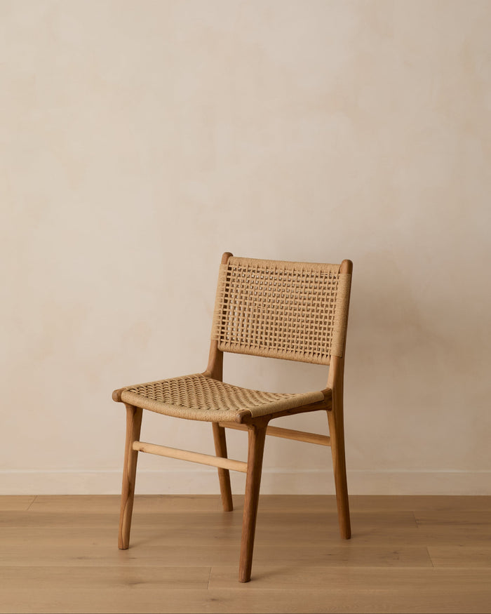 Woven wooden chair against a beige wall