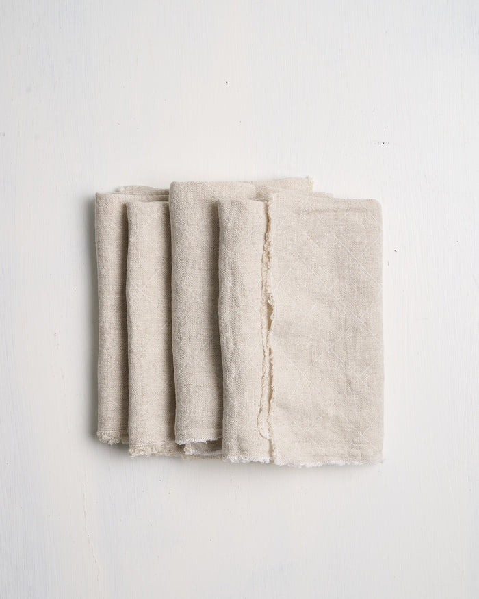 Set of four beige Philo Linen napkins on a white background