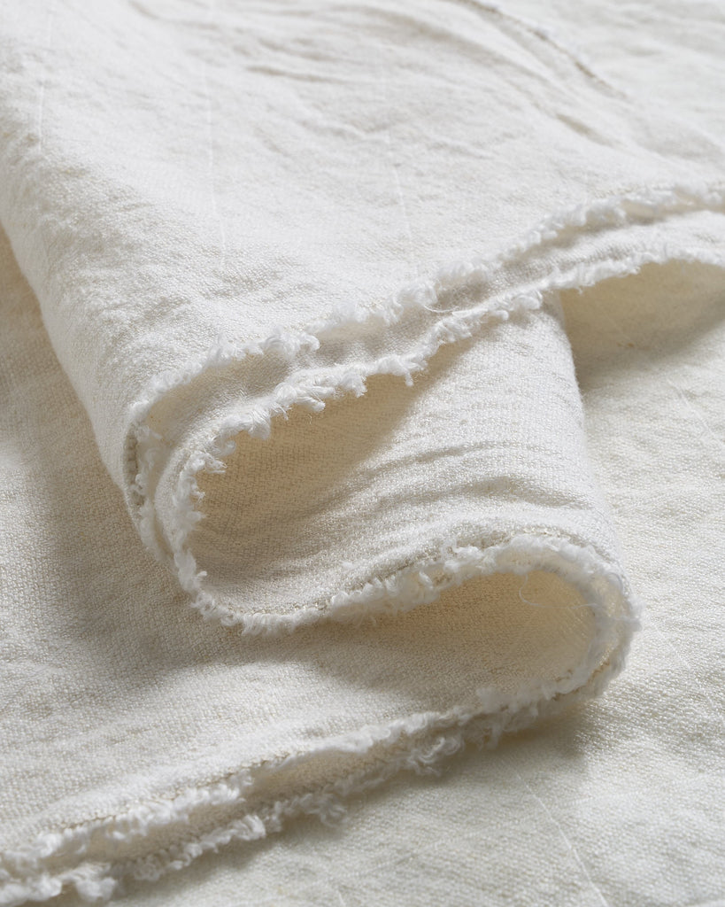 Close-up of a textured white Philo linen tablecloth with folds