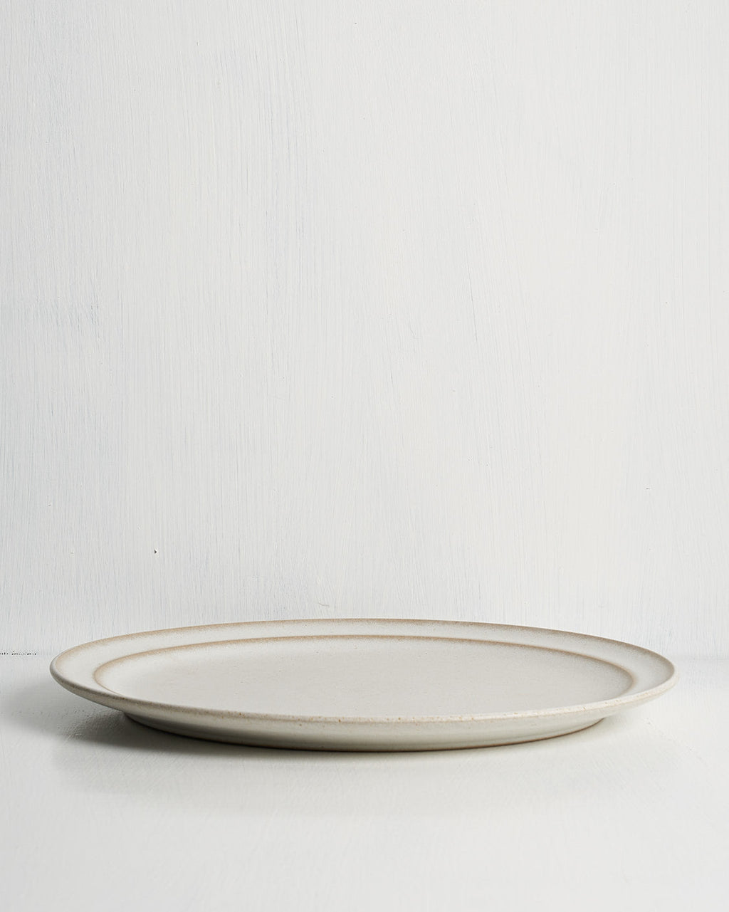White ceramic Pillar Dinner plate with natural rim on a white background