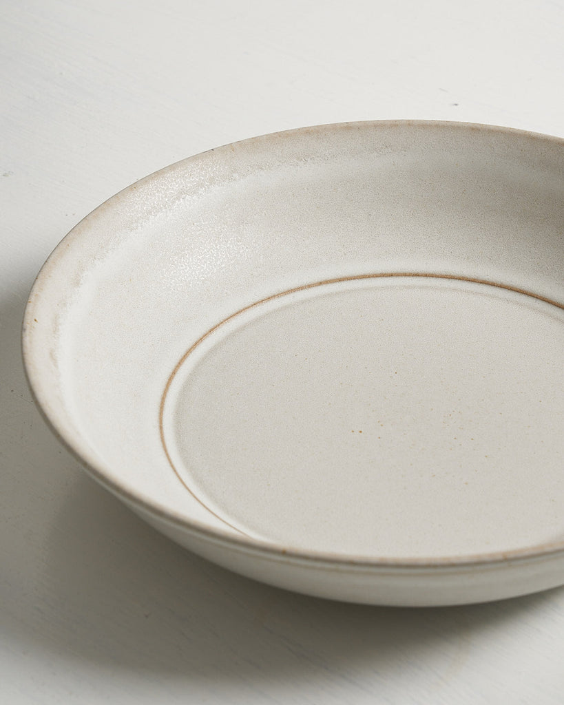 White ceramic Pillar Low Entree Bowl with a gold rim on a light gray background