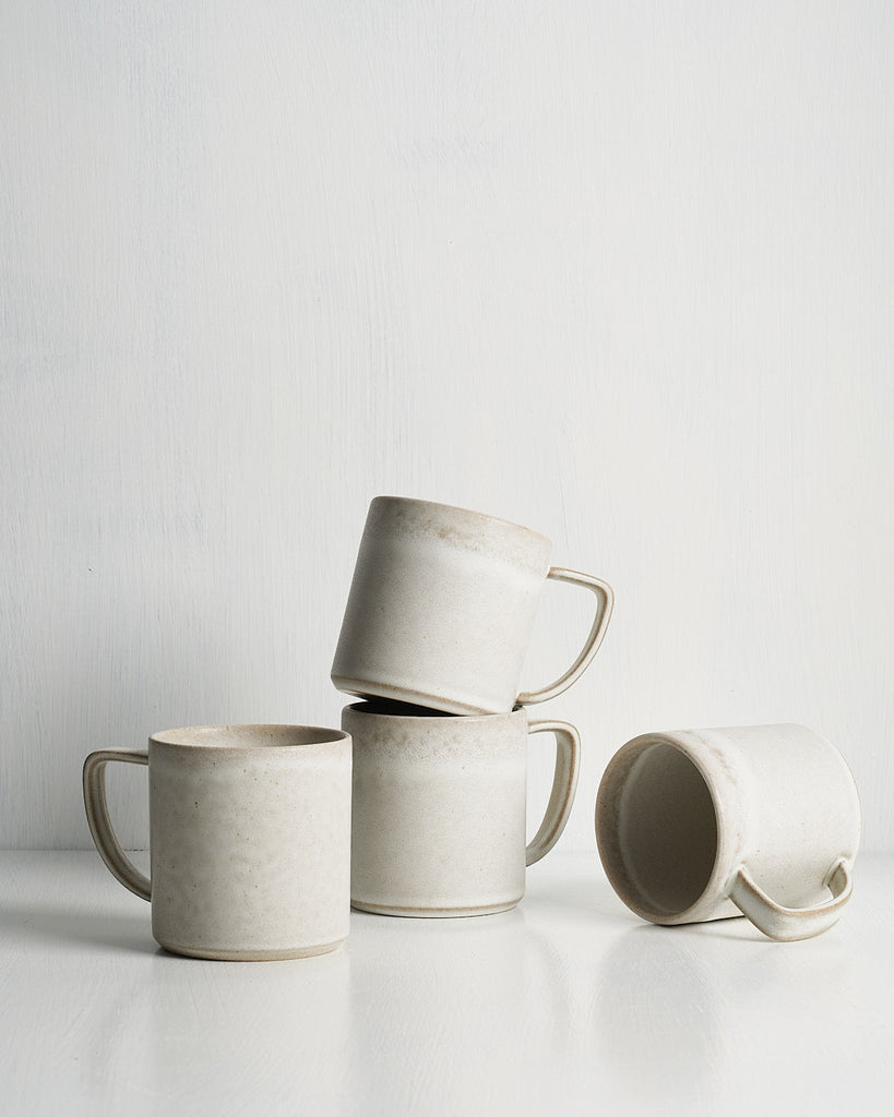Set of four ceramic Pillar mugs stacked on a white surface with a light gray background
