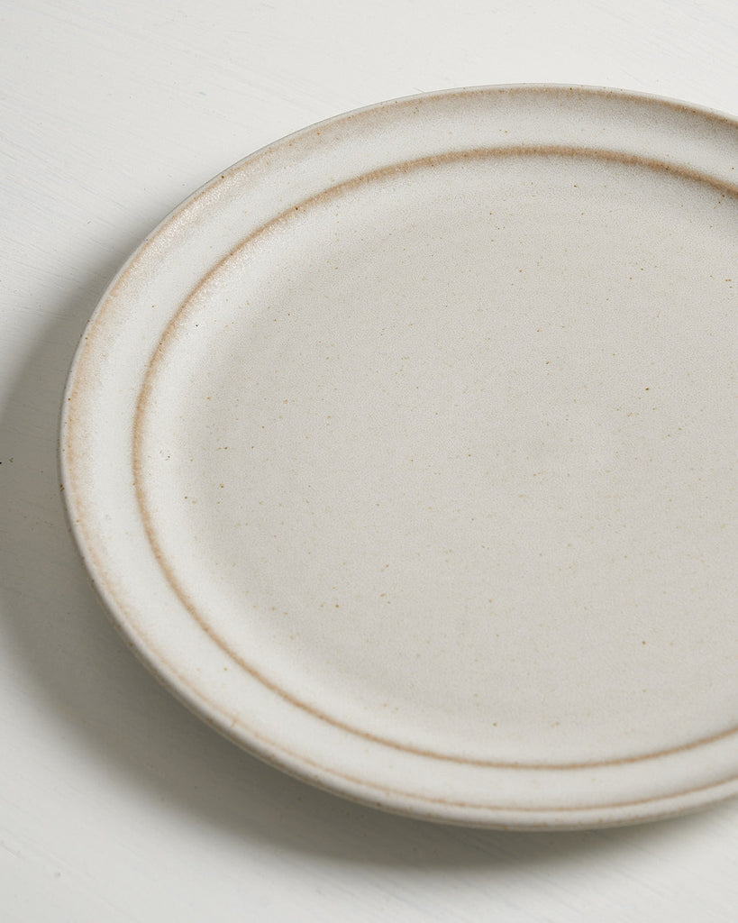 Detail of beige ceramic Pillar Salad plate on a light gray background