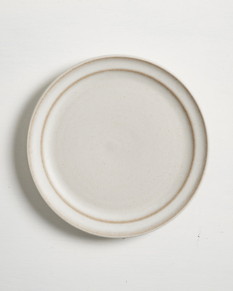 Round ceramic Pillar Salad plate with a thin brown rim on a white background