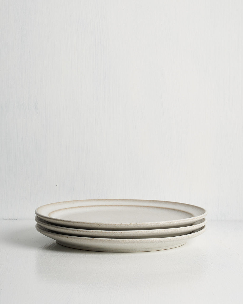 Three ceramic Pillar Salad plates stacked on a white surface with a light gray background