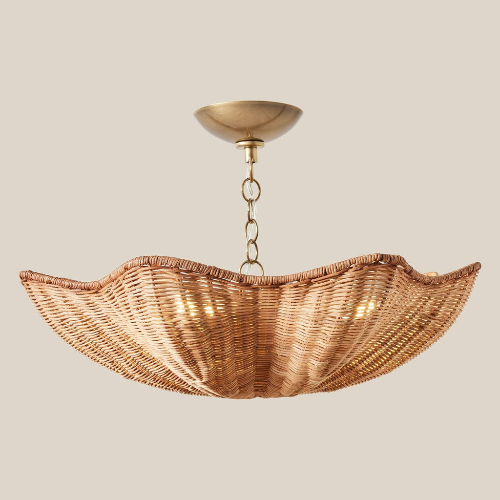 Ravello wicker pendant light fixture with antique brass canopy and chain on a beige background