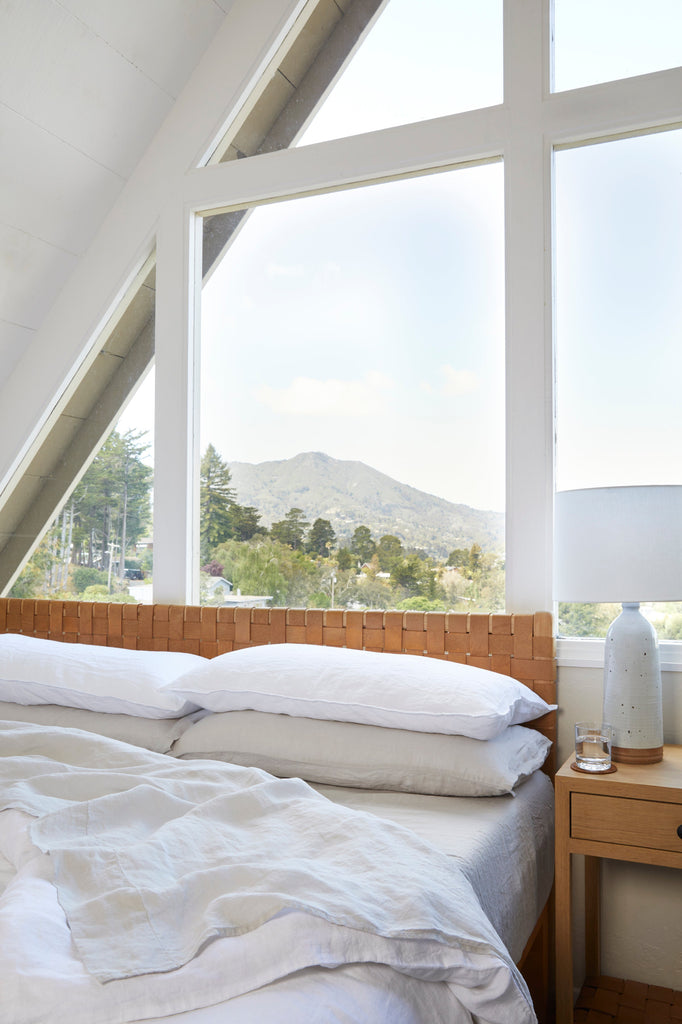 Bedroom with large windows offering a view of mountains and trees