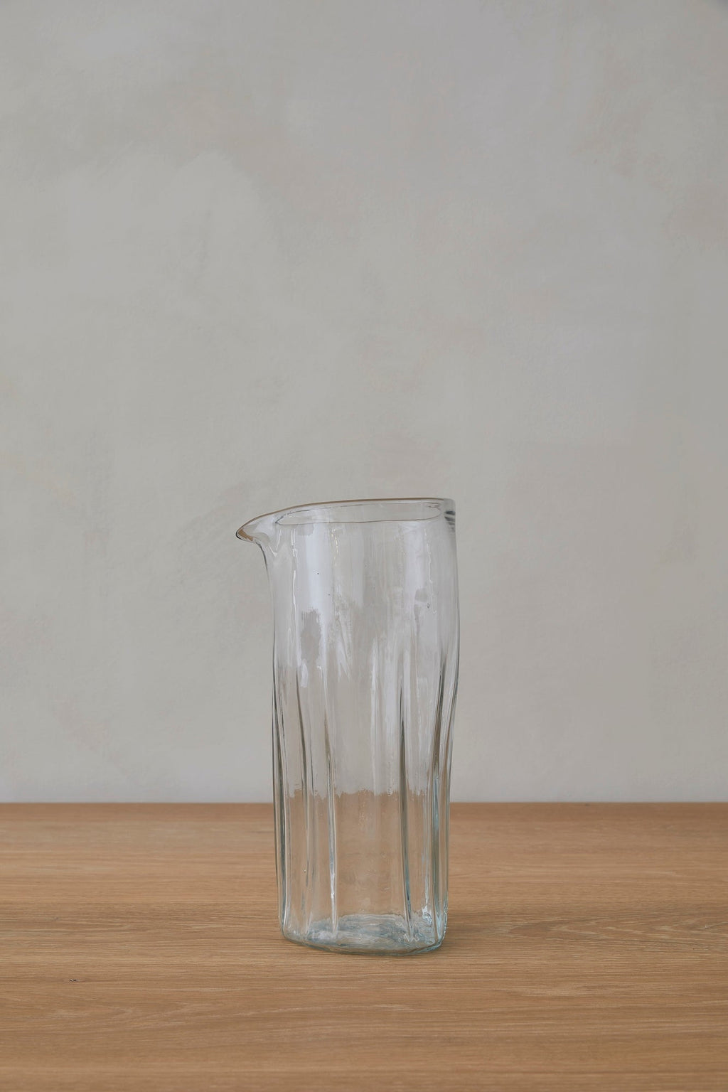 Handblown glass pitcher made from recycled glass with unique texture and classic shape