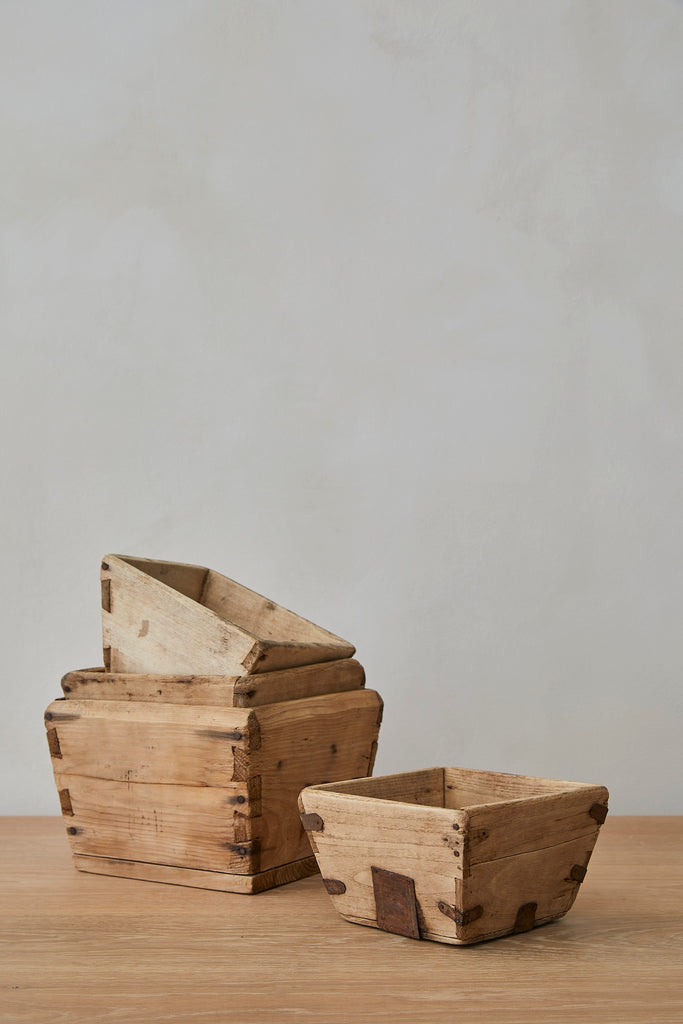 Two wooden boxes on a wooden surface with a plain background