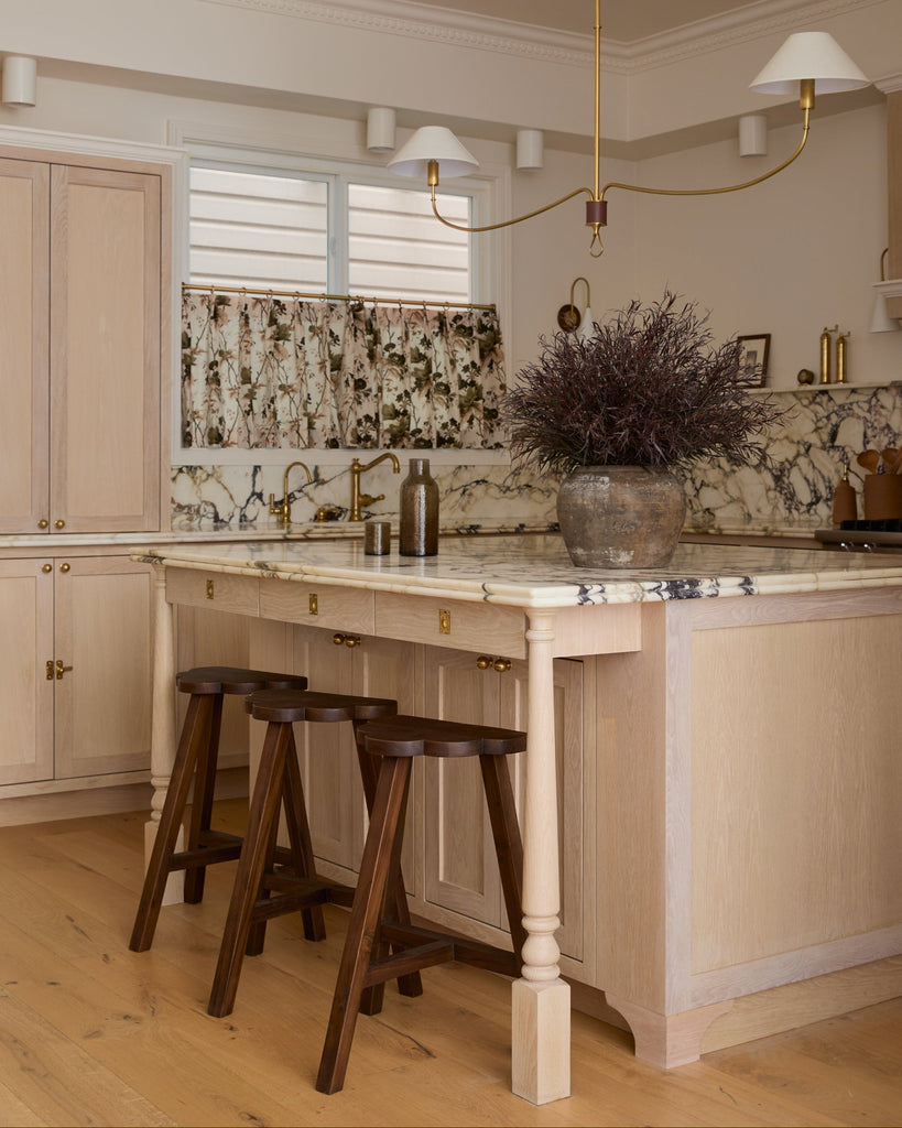 Kitchen with marble island, cloud counter stools, and decorative elements.