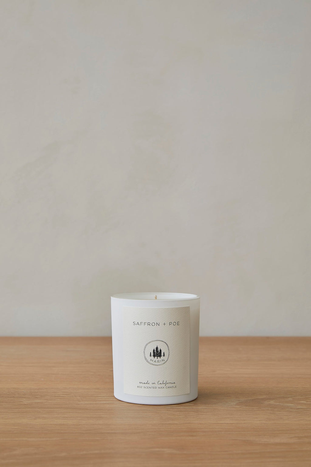 Marin Candle in elegant glass jar with sophisticated scent notes of santal, cardamom, lily of the valley, amber mist, and leather
